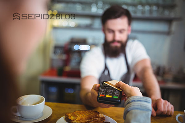 Customer paying with card and cash at cafe
